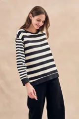 Sweater de punto a rayas horizontales anchas en color negro y crudo, de corte oversize, mangas largas y cuello redondo.
