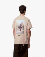 Camiseta blanca de manga corta con un pequeño gráfico en azul oscuro en el pecho izquierdo que dice "CARHARTT" y un número debajo.