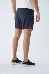 Short de baño amarillo con cintura elástica y cordón ajustable. Presenta bolsillos laterales, un bolsillo trasero y logo bordado en la parte inferior. Incluye suspensor interno y está confeccionado en tela ligera de secado rápido.