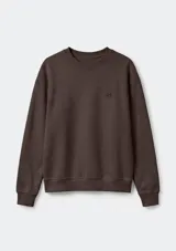 Buzo deportivo de cuello redondo, manga larga con puños y ruedo acanalados. Presenta un pequeño bordado decorativo en el pecho.