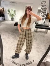 Pantalón tipo balloon de tejido plano con calce relajado, cintura elastizada y estampado cuadrillé en tonos marrones y beige.