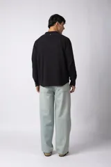 Camisa de lino blanca de manga larga, con cuello clásico y cierre frontal con botones. Corte recto y holgado.