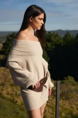 Sweater de punto con textura acanalada, cuello alto tipo polerón, mangas largas abuchonadas y puños anchos.