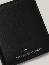 Billetera plegable Tommy Hilfiger de cuero granulado color negro, con logo en relieve en el frente y cinta distintiva en el interior.