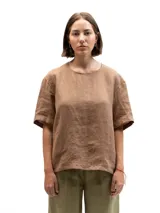 Remera de lino de corte oversize, color marrón, con mangas cortas y botones decorativos en la parte posterior.