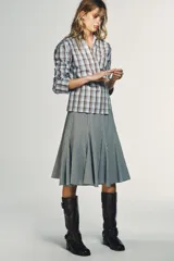 Camisa de algodón con estampado a cuadros en tonos celeste y marrón. Presenta cuello solapa, escote pico y diseño cruzado con lazada frontal.