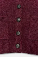 Chaqueta de punto de corte cropped y manga larga, con cuello redondo y cierre frontal de botones. Presenta dos bolsillos de plastrón en la parte delantera y acabados en rib.