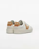Championes Veja modelo V-90, de diseño urbano en color blanco con detalles en gamuza color tostado en el logo lateral, talón y puntera. Presentan perforaciones en la parte delantera y suela de goma al tono.