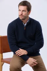 Buzo tejido de lana con cuello alto y medio cierre metálico frontal. Presenta puños y ruedo acanalados, con logo bordado en el pecho.