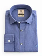 Camisa de lino color blanco, manga larga, con cuello corto clásico y bordado de un ave oscura en el pecho.