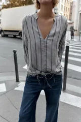 Blusa de manga larga con cuello redondo y escote en pico, cierre frontal con botones y diseño de rayas verticales.