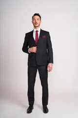 Traje de vestir para hombre compuesto por saco de dos botones y pantalón de corte recto, en color negro. El saco presenta solapas clásicas, bolsillos con solapa y un bolsillo superior en el pecho. Incluye camisa blanca, corbata roja y pañuelo de bolsillo a juego.