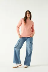 Sweater de punto color salmón, con cuello redondo y mangas largas.