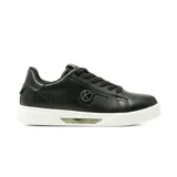 Championes urbanos Korium modelo Alida, de color negro con suela blanca y detalle metálico dorado en el lateral de la entresuela. Presentan un diseño de ecuero con cordones al tono y logo circular decorativo en el lateral.