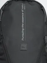 Mochila negra con múltiples bolsillos con cierre, correas ajustables y logo de la marca en el frente.