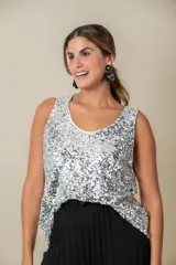Blusa sin mangas confeccionada en tela cubierta de lentejuelas doradas y plateadas, con escote redondo y corte holgado.