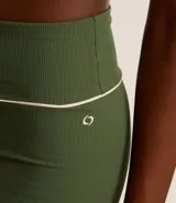 Bermuda deportiva de microfibra acanalada color verde militar, corte ajustado y cintura alta con friso contrastante blanco.