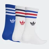 Pack de tres pares de medias Adidas de caña media, con diseño deportivo que incluye las tres bandas características y el logo del trébol bordado. El set incluye un par azul con bandas blancas y dos pares blancos con detalles de bandas en colores rojo, azul y negro.