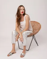 Pantalón negro estilo jeanero confeccionado en gabardina elastizada con terminación metalizada, pierna recta con largo por arriba del tobillo, cierre delantero y botón.