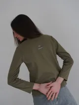 Remera manga larga color verde seco, de corte recto y cuello redondo.