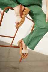 Sandalias marrones con plataforma y tiras de cuero marrón, beige y blanco.