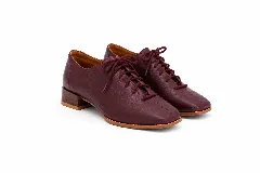 Zapatos acordonados de cuero color negro, con diseño de punta cuadrada, costuras centrales decorativas y suela marrón con taco bajo.