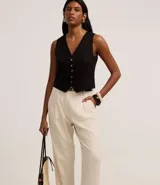 Pantalón zanahoria de cintura alta color crudo, confeccionado en viscolino con trabillas en la cintura, pliegues y solapas traseras. Incluye cinturón fino con hebilla confeccionado en PU.