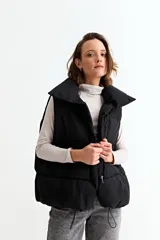 Chaleco puffer de corte holgado y diseño acolchado, con cuello alto y cierre frontal oculto. Presenta cordón ajustable en el ruedo inferior y bolsillos laterales.