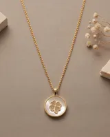 Collar de bronce dorado con cadena fina y dije redondo que presenta un fondo de nácar blanco y un trébol de cuatro hojas en el centro.