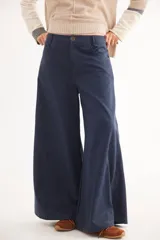 Pantalón de tiro medio con diseño de pierna ancha y cortes curvos que aportan movimiento. Presenta cintura ajustada, bolsillos delanteros y bolsillos plaque en la parte trasera.
