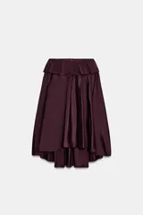 Falda midi asimétrica de color bordó, confeccionada en tejido satinado con volumen. Presenta un diseño con volados en la cintura y cierre de cremallera oculta en la espalda.