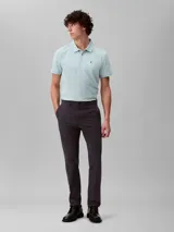 Pantalón de corte slim confeccionado en mezcla de algodón elástico, con cierre de botón y cremallera, diseño de cinco bolsillos y estilo versátil.