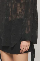 Camisa de gasa jacquard negra con motivo floral, de calce regular, manga larga con lazos y diseño con ruedo trasero más largo.