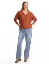 Buzo de tejido fino con escote en V, mangas tres cuartos estilo dolman y corte holgado.