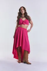 Pollera larga fucsia con corte irregular y cintura elastizada.