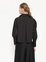 Camisa blanca de poplin, con bordado JCH a tono en el ruedo, cartera oculta con botones a tono, cartera en puños con botones a tono y bajo redondeado.