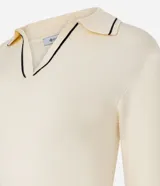 Blusa femenina de punto color blanco crema, con cuello polo y escote en V. Presenta detalles de biés negro contrastante en el cuello y los puños de las mangas largas.