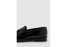 Mocasines de piel vacuna en color negro, de diseño clásico con suela plana y costuras visibles en el empeine.