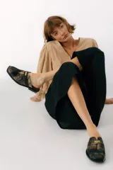 Zuecos de cuero color bordó con punta cuadrada, detalle de abertura en el empeine y aplique metálico dorado.