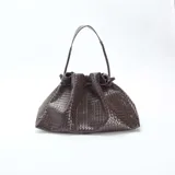 Bolso grande de mano color marrón, con diseño de efecto trenzado y asa superior.