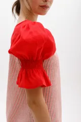 Vestido corto a rayas verticales color gris y blanco, con cuello redondo y mangas cortas abullonadas color amarillo pálido con detalle de elástico en el puño.