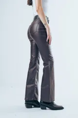 Pantalón de tiro alto confeccionado en eco cuero, con corte tipo oxford ajustado en la parte superior y ligeramente acampanado hacia el ruedo.