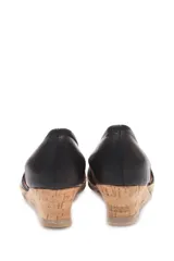 Zapato de taco corrido tipo cuña, confeccionado en cuero negro con aberturas laterales. Presenta una base de corcho y detalle de yute en la puntera.