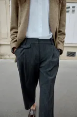 Pantalón de tiro medio con pinzas delanteras y pernera recta. Cuenta con bolsillos frontales, falsos bolsillos traseros de vivo y cierre frontal con cremallera, botón interior y ganchos.
