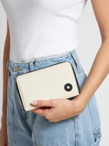 Billetera rectangular color crema con cierre de cremallera y detalle de botón negro con logo de la marca.