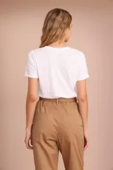 Remera blanca de algodón con cuello redondo y estampado frontal de un sello postal color ocre con un elefante.