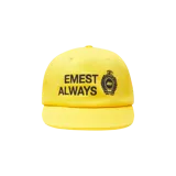 Gorra Eme Studios de color amarillo con visera plana, confeccionada con paneles frontales estructurados. Presenta un diseño bordado en contraste de color negro con la frase "EMEST ALWAYS" y un emblema circular de estilo heráldico.