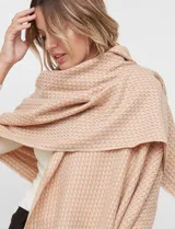 Bufandón tejido de poliéster, color rosa pálido con textura jaspeada en tonos pastel (naranja, lila, gris). Presenta un tejido grueso y flecos en los bordes.