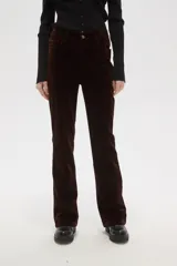 Pantalon de corte flare y tiro alto, confeccionado en tejido de pana color marrón oscuro, con cierre frontal y bolsillos laterales.
