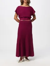 Conjunto de dos piezas Twinset confeccionado en tejido de punto acanalado color bordó. Incluye un top corto de cuello barco con mangas cortas y una pollera larga de corte acampanado.